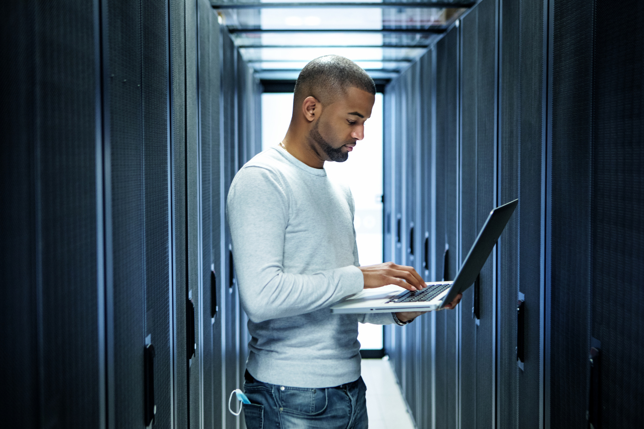 Man checking network security in server room.